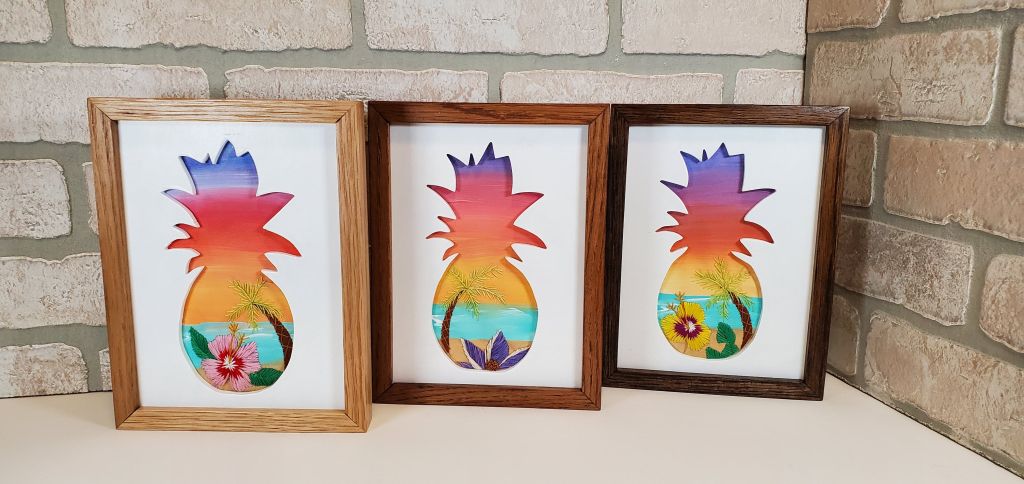 Examples of pineapple silhouette with beach scene background and embroidered tropic flowers and palm tree deatils
