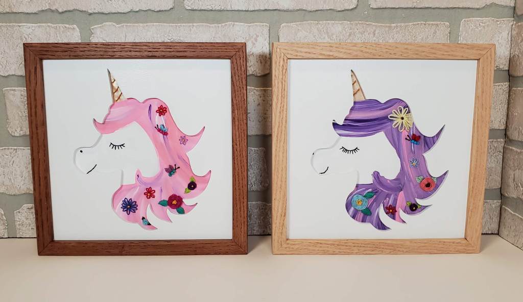 Unicorn head side view silhouette with pink and purple hair, embroidered flower designs