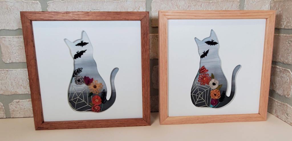 Cat sitting silhouette with gray background and embroidered spiderweb, bats, fall flower details