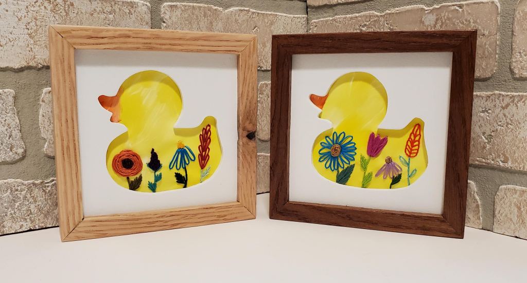 Rubber ducky silhouette with yellow background and embroidered flower details