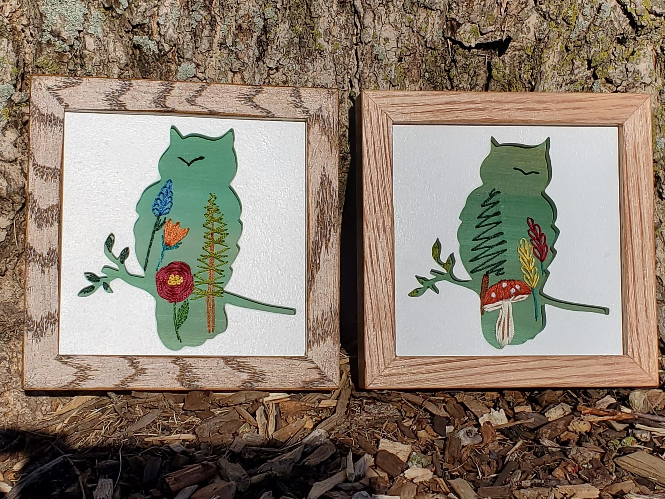 Owl sitting on a branch silhouette. Green background with embroidered flower, tree and mushroom details.