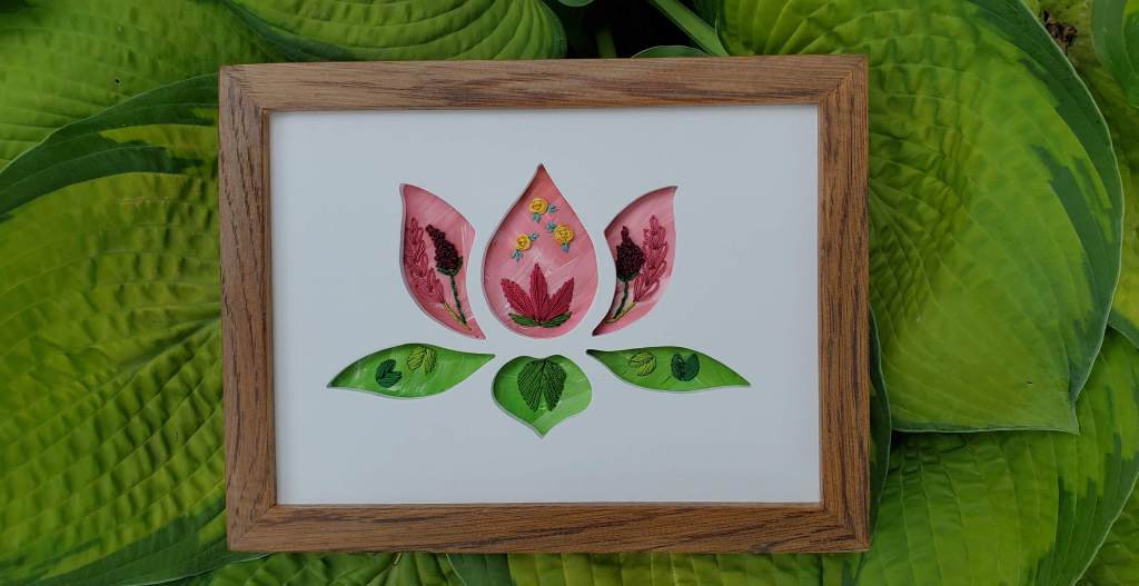 Lotus flower silhouette with pink and green background and embroidered flowers and leaf details.