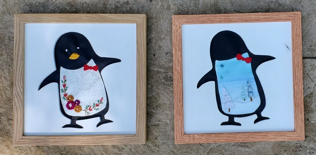 Penguin silhouette with winter scenes in the stomach area with embroidered tree, snowflake and flower details.