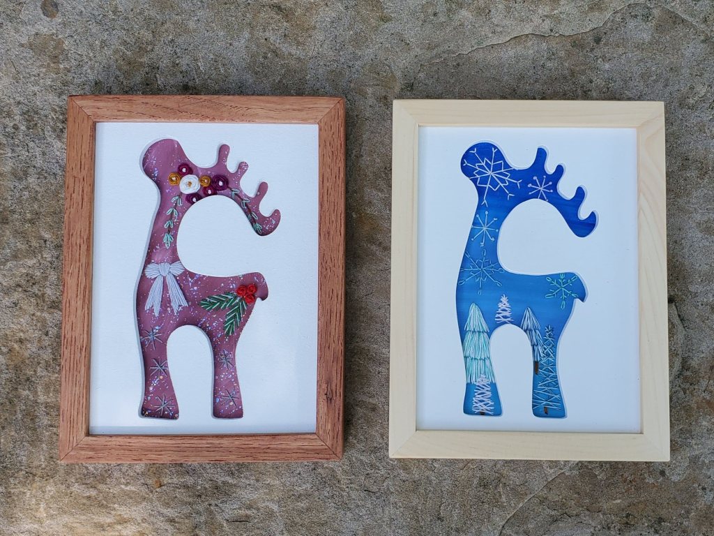 Moose standing side view silhouette with holiday embroidered details, snowflakes, trees, flowers.