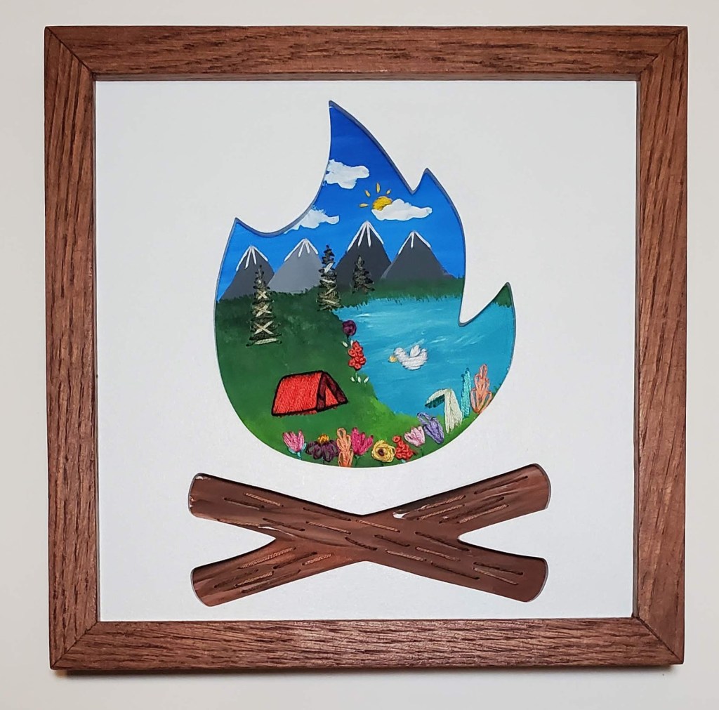 Campfire silhouette with a mountain and lake background with embroidered camping tent, duck, trees and flower details.