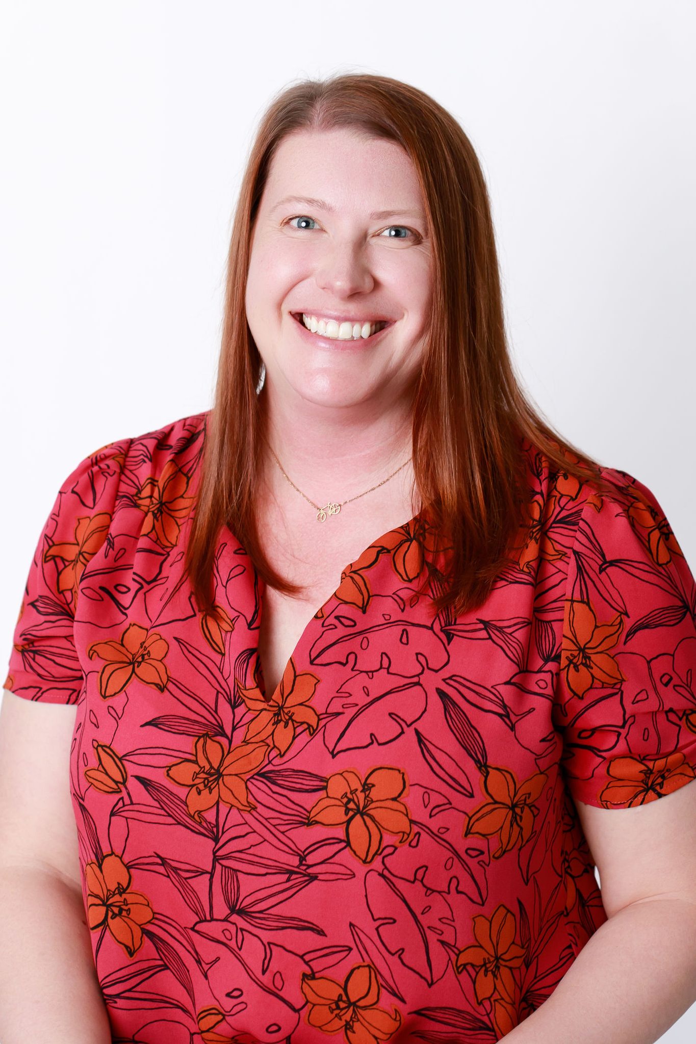 a woman from the waist up wearing a red floral print top.
