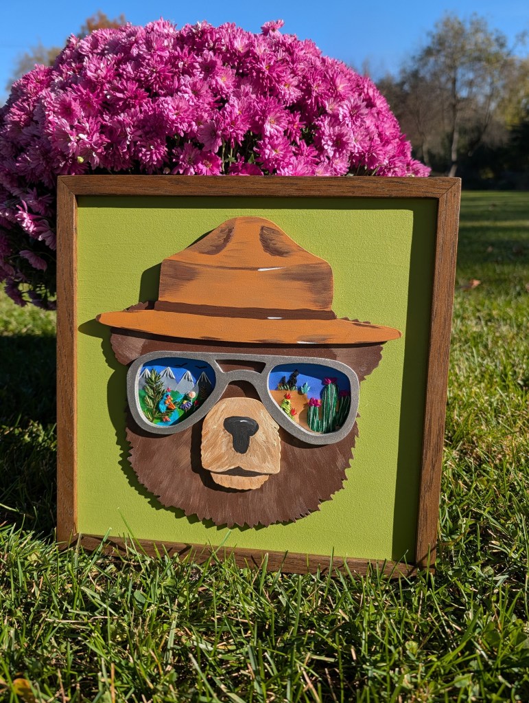 Bear face with aviator glasses and hat. Embroidered details inside the glasses.